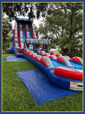 22' water slide with a slip in slide attached loacted in a wooded area.