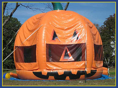 Three Dimensional Pumpkin Themed Bounce House tethered to the ground. 