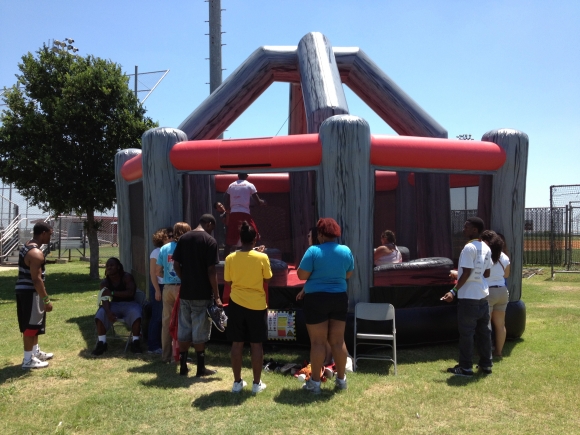 Wrecking Ball Interactive inflatable game being played outdoors by teenagers and children on a sunny day