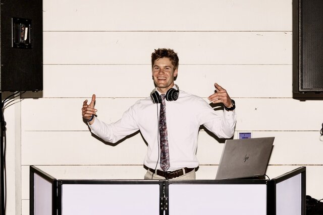 DJ smiling while posing for the camera at an event.