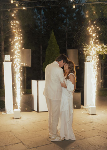 DJ with pyrotechnics behind bride and groom at a wedding