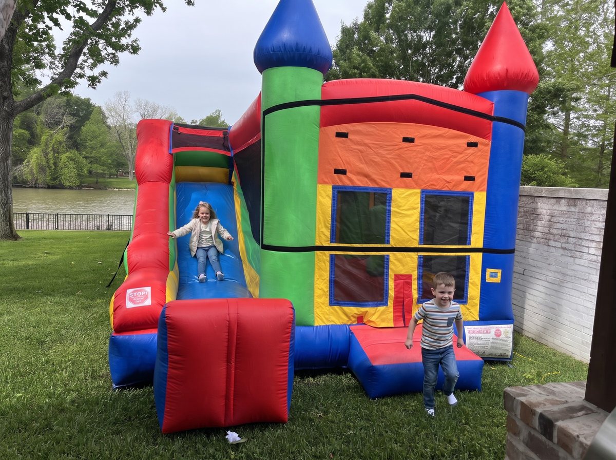 Kids on a Classic Combo 4 in 1 bounce house with slide in a lakeside Sugar Land backyard