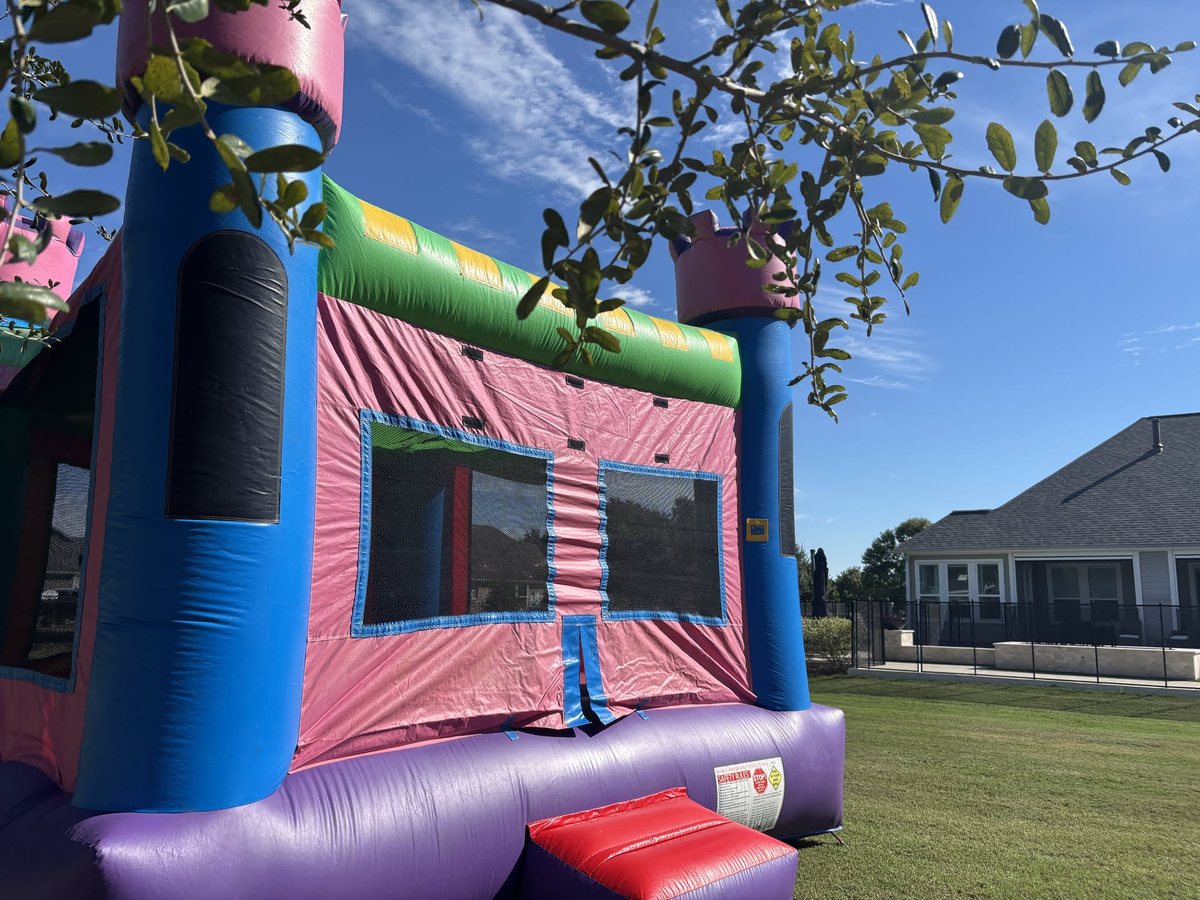 Pink Palace bounce house set up on a Katy lawn