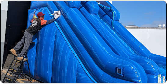 Party With 630 team cleaning and preparing inflatable water slides before delivery as part of the Party With 630 Stress-Free Guarantee