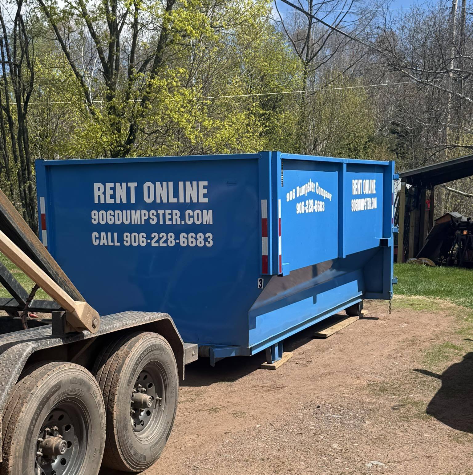 Blue dumpster delivered to a residential property in Negaunee, MI
