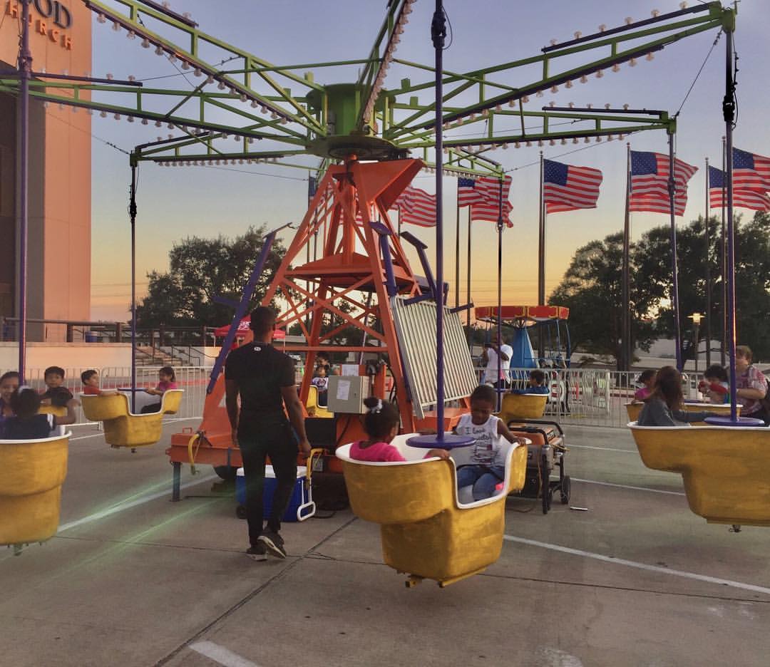 Events by ABA carnival swing ride with children and American flags.