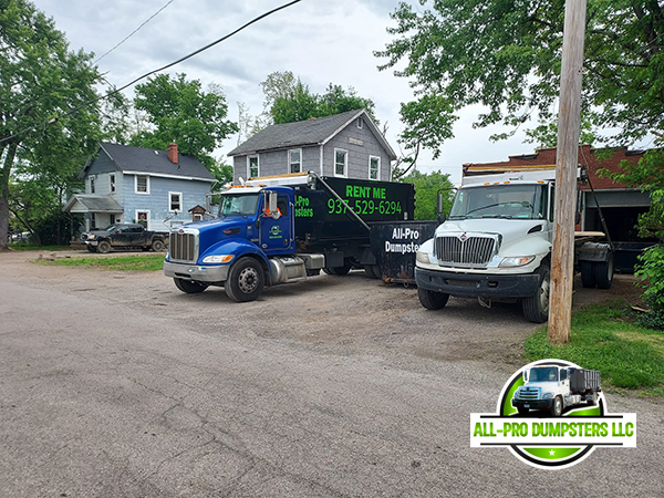 Image of a roll-off dumpster being delivered to a residential or commercial location by All Pro Dumpsters LLC personnel.