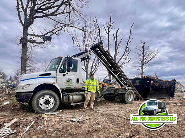 All Pro Dumpsters truck delivering a roll-off dumpster to a residential driveway in Beavercreek, Ohio