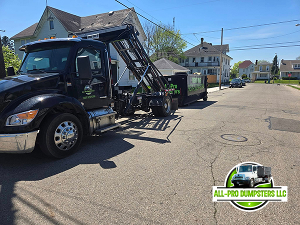 All-Pro Dumpsters truck delivering a roll-off container to a residential driveway in Riverside, Ohio