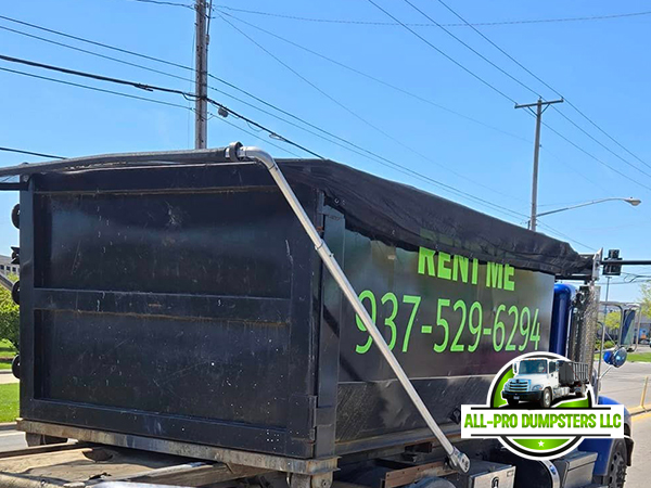 ll Pro Dumpsters truck delivering a roll-off dumpster to a residential driveway in Vandalia, Ohio