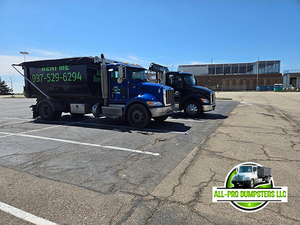 Side-view of an All-Pro Dumpsters truck placing a clean, empty roll-off container for a home renovation project