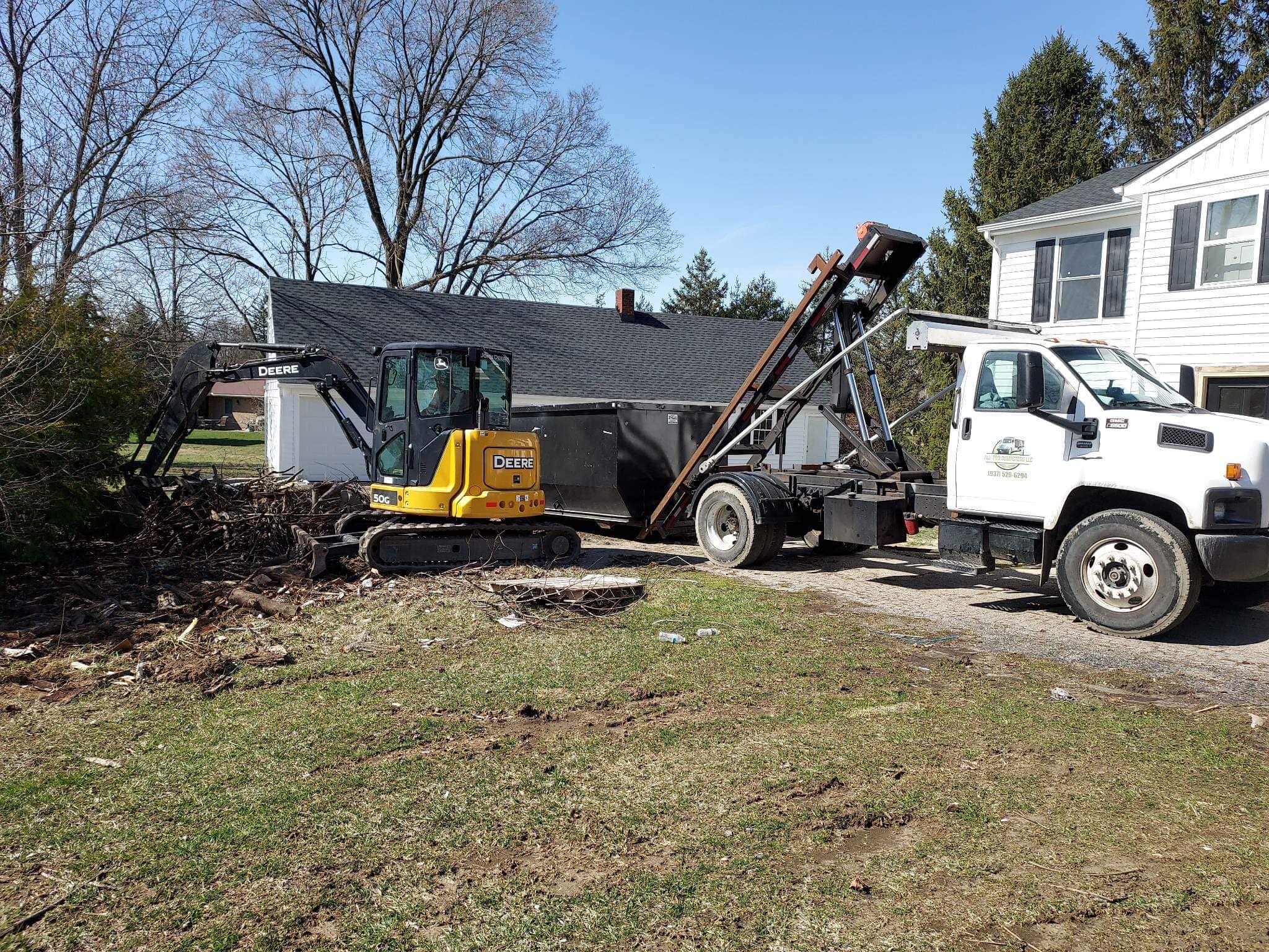 All-Pro Dumpsters roll-off container being used for a construction cleanup project with an excavator.
