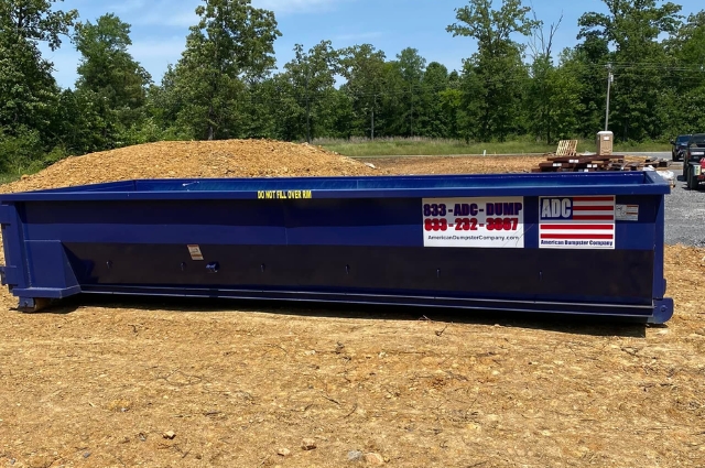 A construction roll-off dumpster from American Dumpster Company on a jobsite