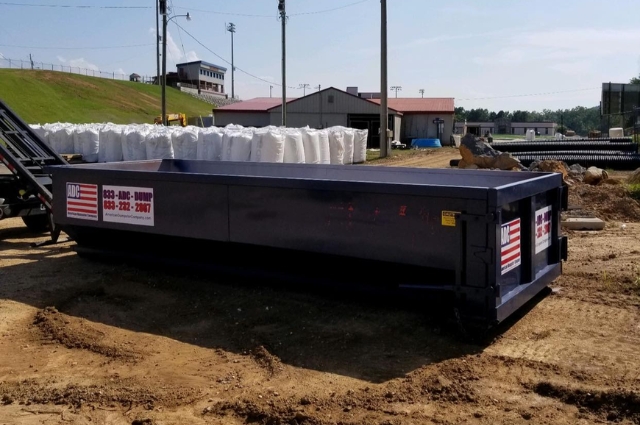 A roll-off dumpster from American Dumpster Company on a construction site