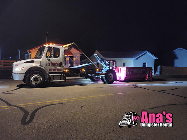 Dumpster delivery at night with pink bin — Ana's Dumpster Rental