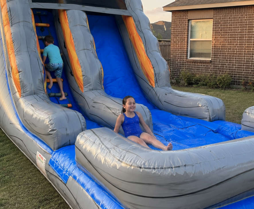 Gray and blue inflatable water slide set up for a backyard party in Venus, Texas.
