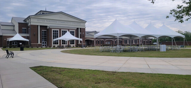 Event tents and seating arranged outside a community college building for a large gathering