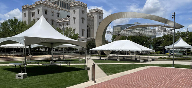 Large event tent setup at an outdoor festival with branded pop up tents and temporary fencing