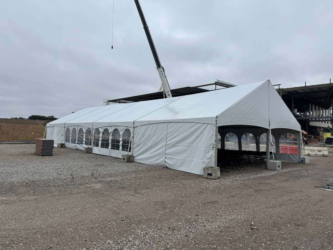 Frame tent with climate control units set up in a corporate lot for a plant event