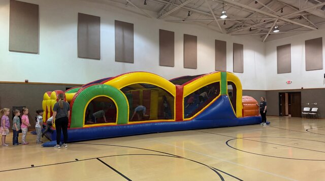 40' Extreme Obstacle Course setup in a gymnasium with kids playing and teachers watching.