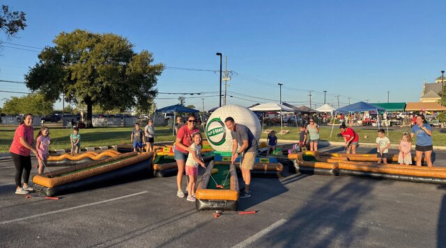 Kids and parents playing mini golf on the 9-Hole Mini Golf rental from Austin Bounce House Rentals in Austin Texas.