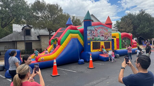 Carnival themed super duper combo 5-in-1 setup outdoors with kids playing and happy parents.