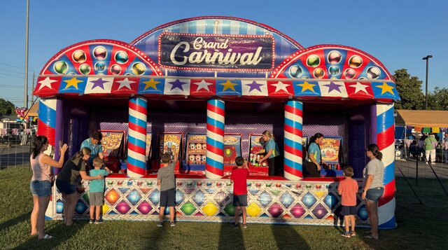 Joyful kids and parents playing carnival games on the Grand Carnival Experience from Austin Bounce House Rentals in Austin Texas.