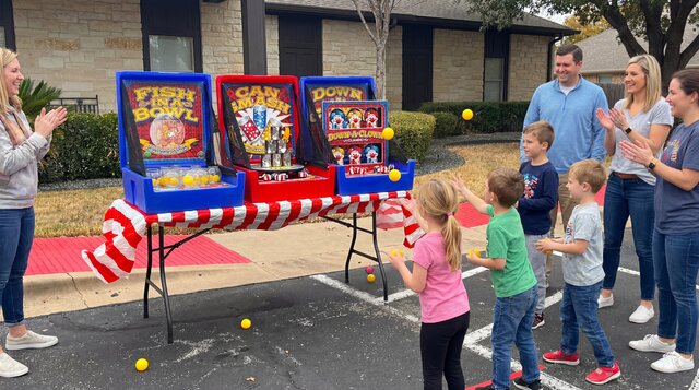 3-Game Home Carnival rental from Austin Bounce House Rentals setup outdoors and smiling people.