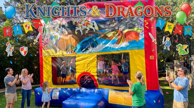 Knights & Dragons bounce house rental from Austin Bounce House Rentals™ setups outdoors with kids playing