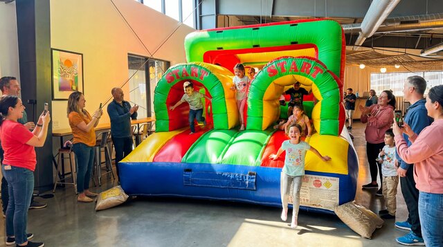 Backyard Fun Course setup indoors with kids playing and parents watching