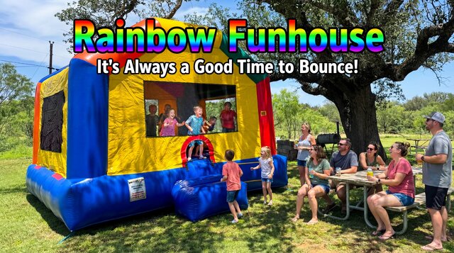 Rainbow Funhouse bounce house setup in a backyard with family having fun.