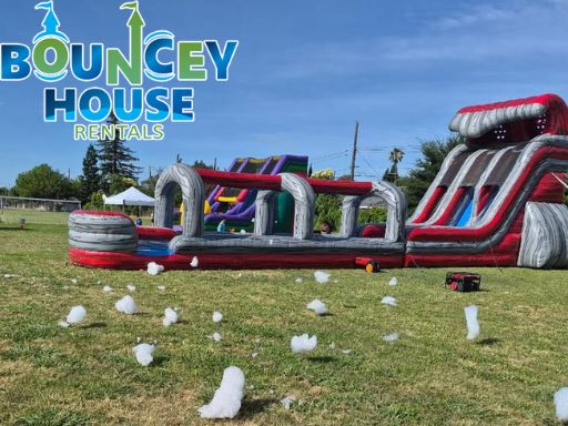 Commercial-grade inflatable water slide rental from Bouncey House Rentals set up for a Sacramento area party with splash pool and safety anchoring