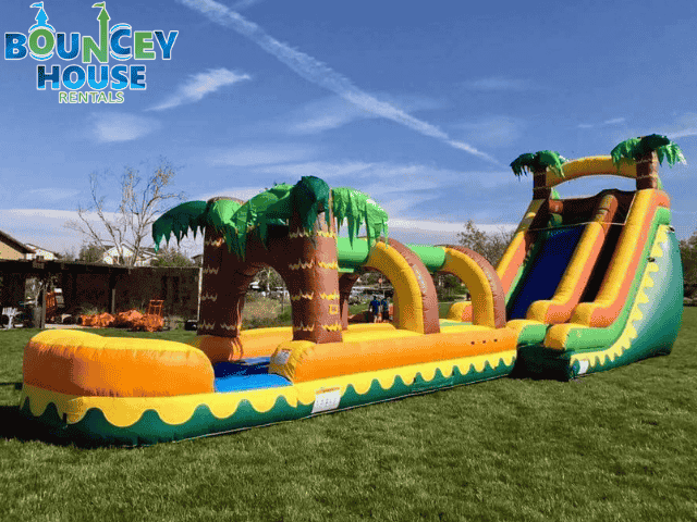 Water slide rental in Rancho Cordova showing a huge yellow water slide with a slip n slide landing