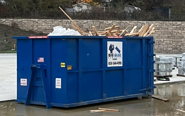 A residential junk removal project using a Big Blue Dumpster filled with renovation debris