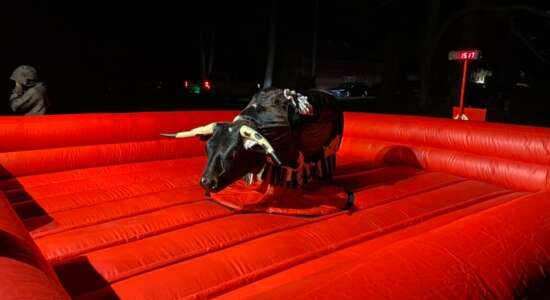 Mechanical bull ride on red inflatable mat from Big Bounce Party Rentals