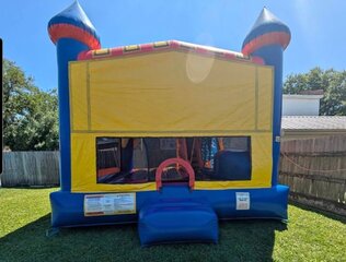 A RED BLUE AND YELLOW CASTLE BOUNCE HOUSE