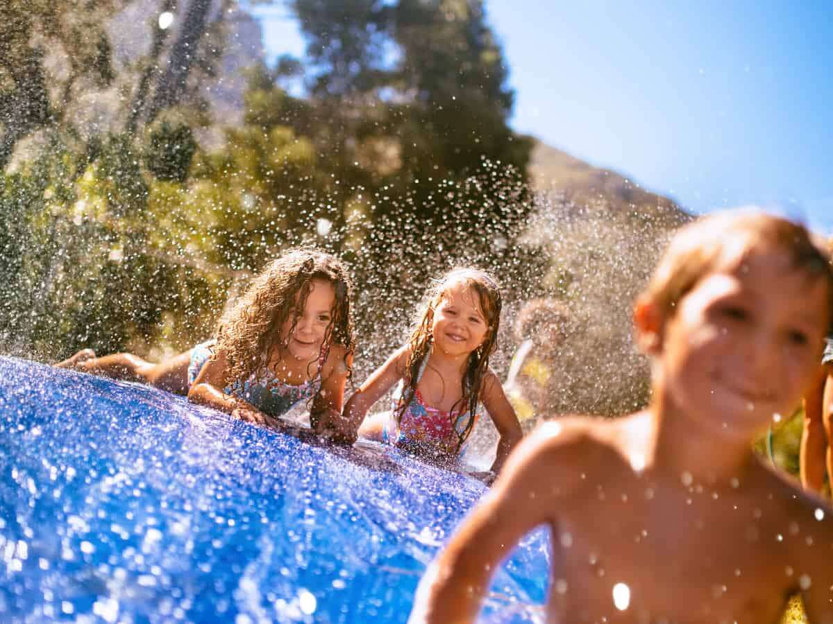 Kids playing on backyard water slide