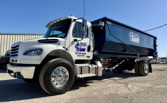 Blue Giant Dumpsters roll-off truck with blue container outdoors.