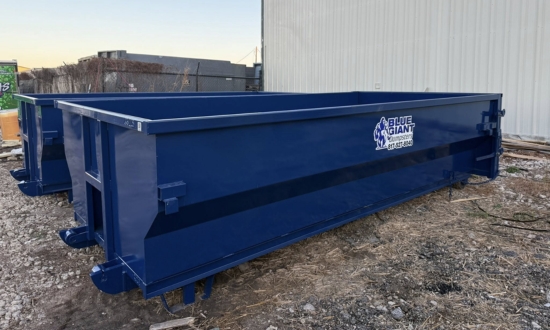 Blue Giant Dumpsters open-top dumpster positioned beside a building.