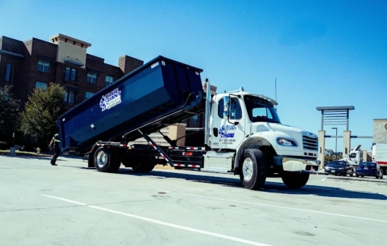 Blue Giant Dumpsters roll-off container being lowered by a truck.