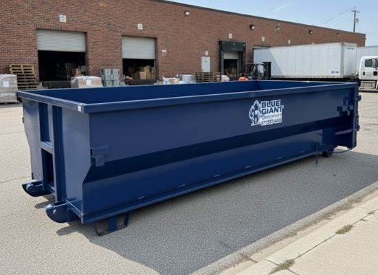 Blue Giant Dumpsters roll-off container placed outside a warehouse.