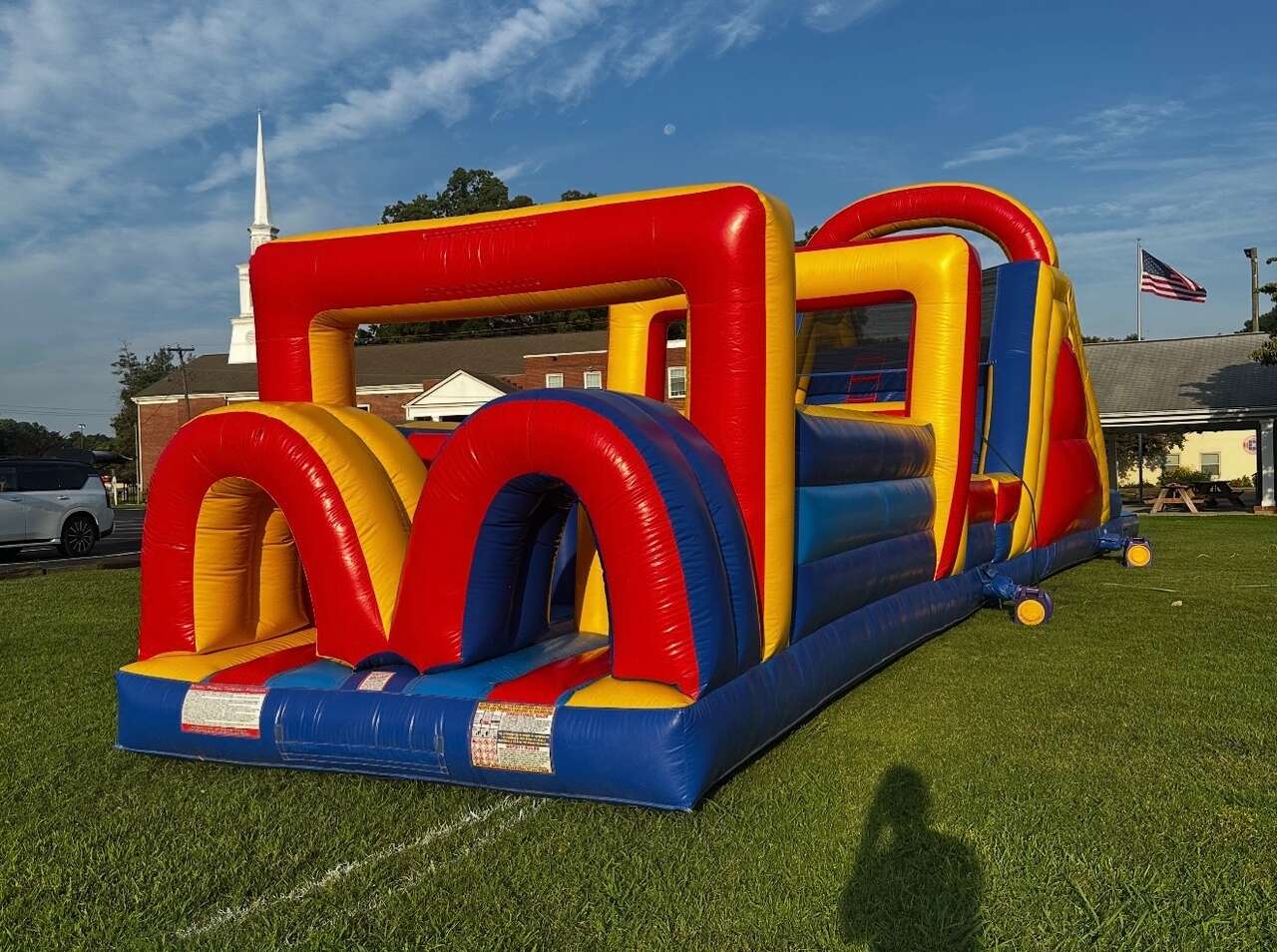 Families gathered at a church fall festival with games and a bounce house