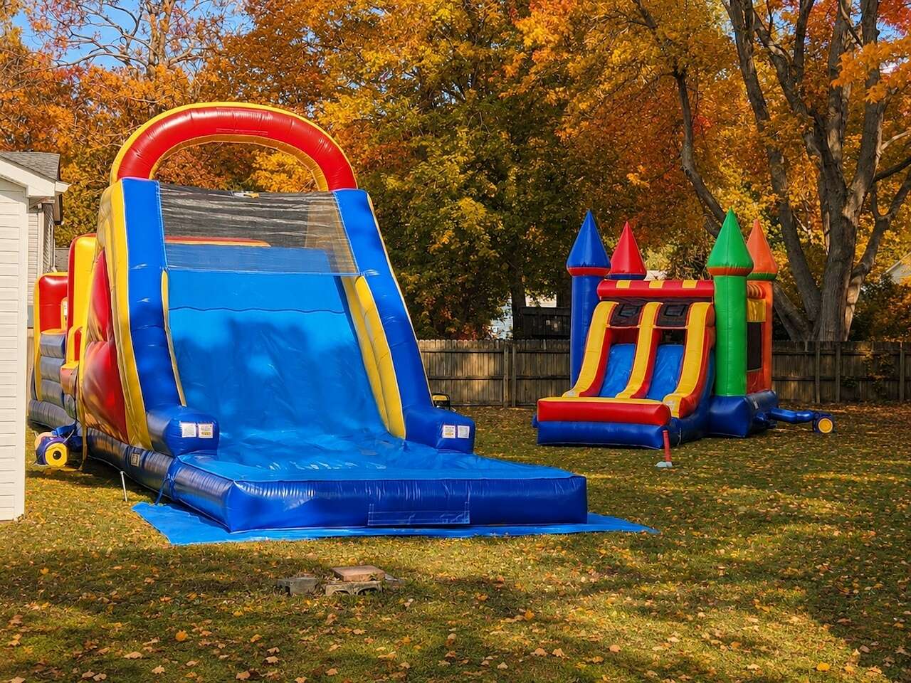 Kids jumping in a bounce house set up in a backyard on a cool fall afternoon in Hampton Roads