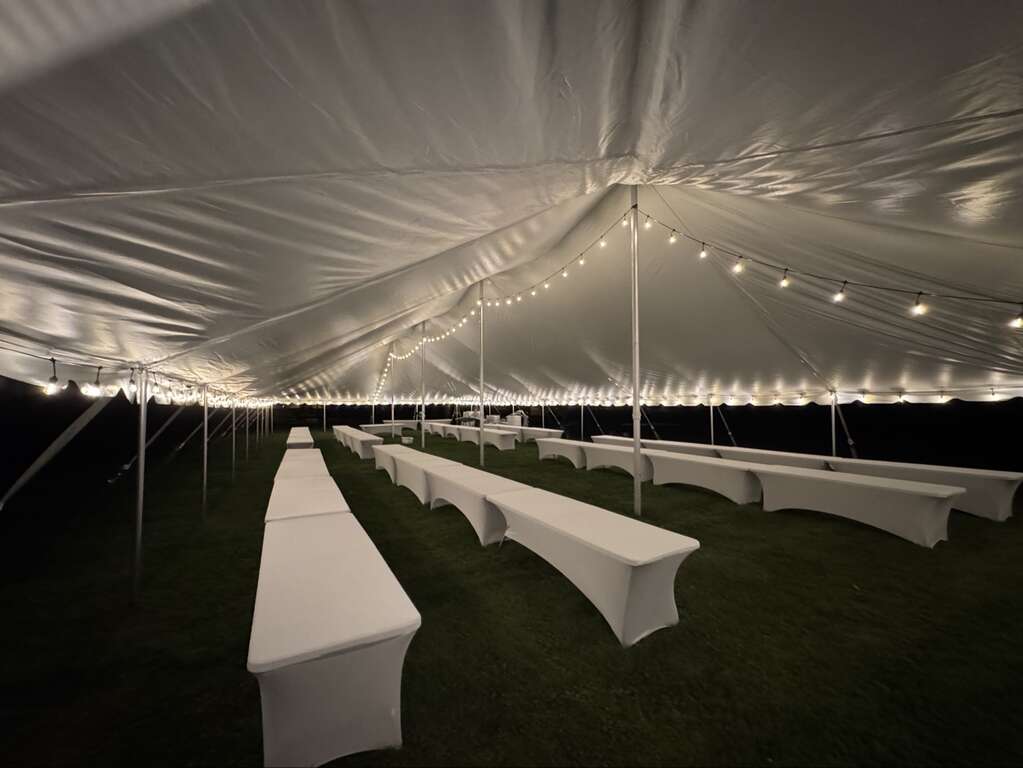Inside a 40x100 pole tent with string lights