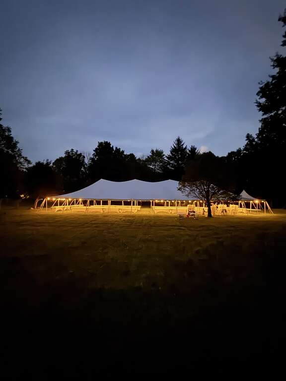 Pole tent with string lights at dusk