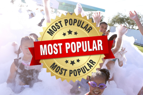 Foam party with bubbles covering the ground and people playing outdoors