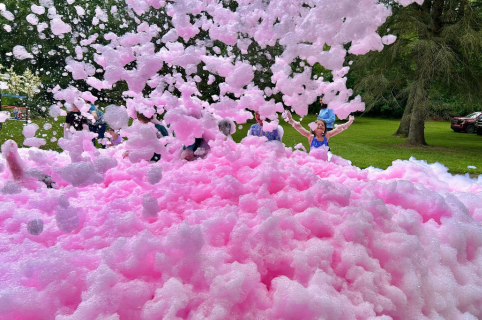 Color foam party with vibrant colored bubbles covering outdoor event space