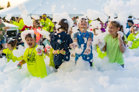 Premium foam party rental with high-output foam machine filling large event area with bubbles
