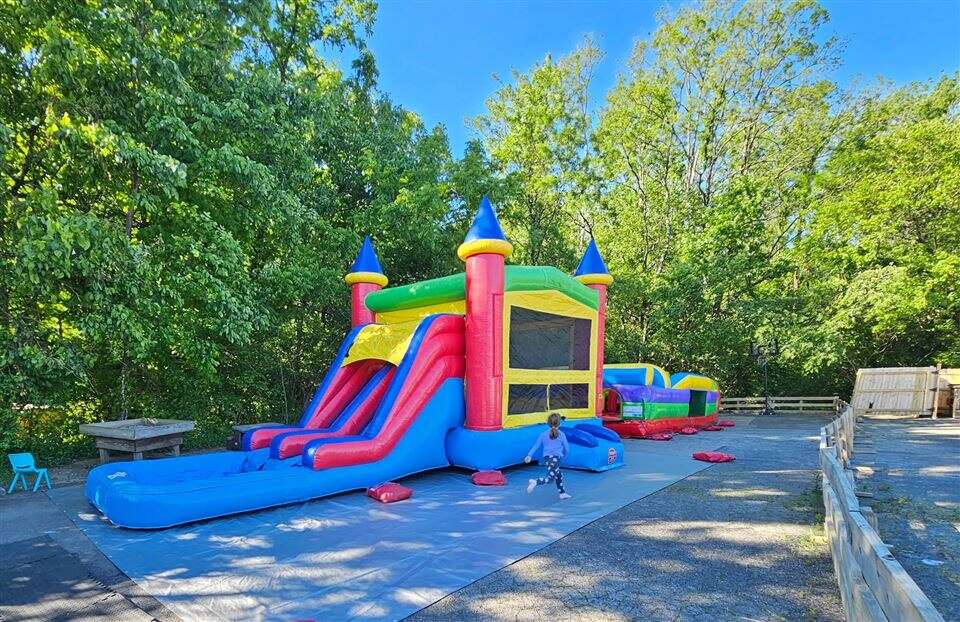 Castle combo with slide and an inflatable obstacle course set up on pavement at JET Education Center in Amelia, Ohio