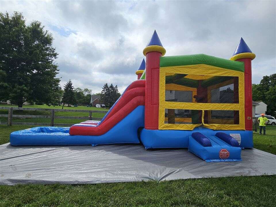 Rainbow castle bounce house combo with slide set up for a Memorial Day party in Batavia, Ohio